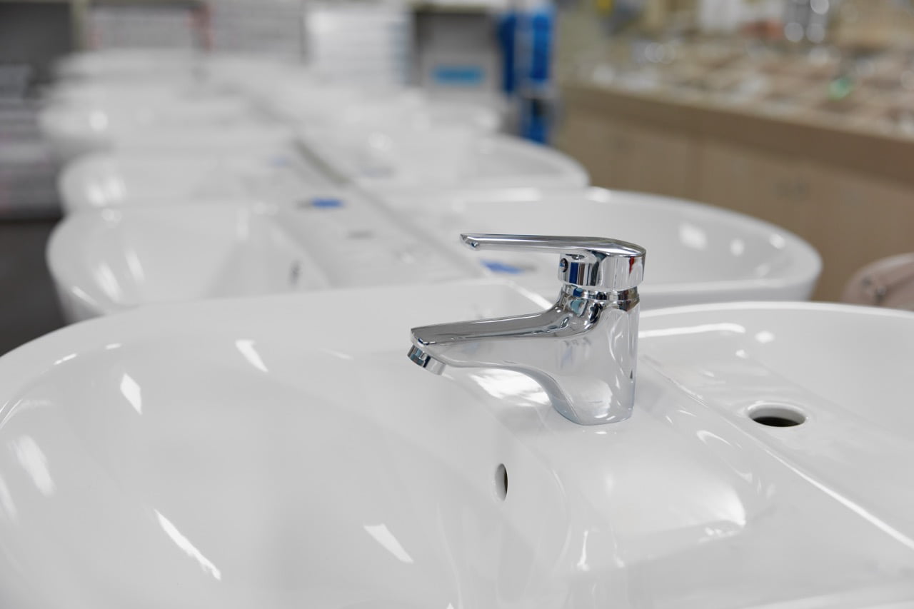 Modern classic ceramic sink assortment at plumbing shop closeup selective focus. Variation of washbasin for lavatory room design interior at store showcase